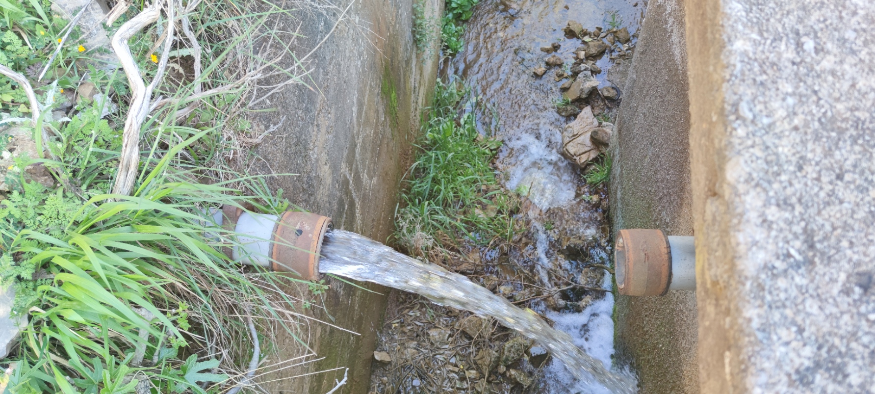 Ροή νερού σε πρόχειρο αυλάκι προς το ρέμα